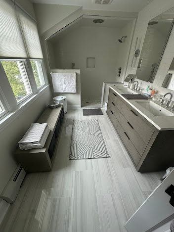 A bathroom with two sinks and a walk in shower.