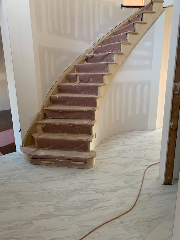 A wooden staircase is being built in a house.