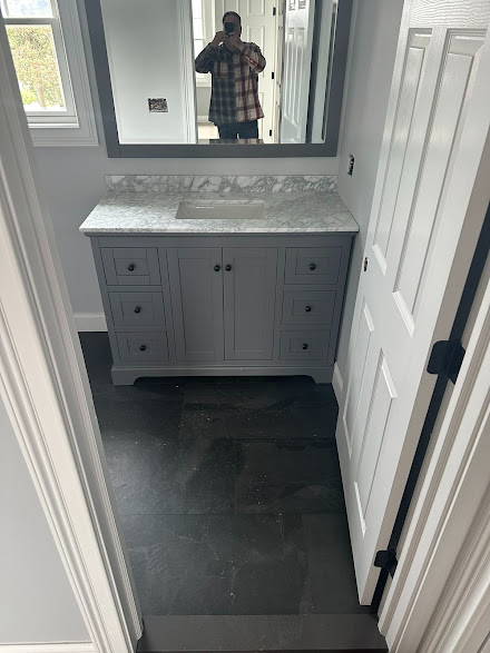 A man is taking a picture of himself in a bathroom mirror.