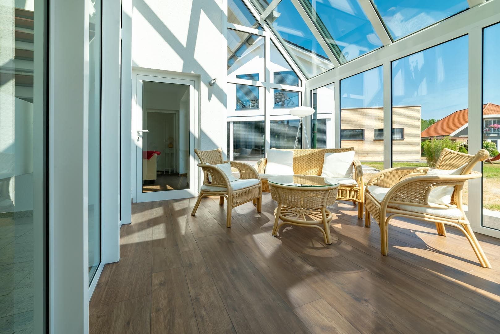 A living room with wicker furniture and a glass ceiling.