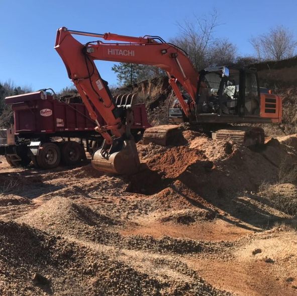 A hitachi excavator is digging a hole in the dirt