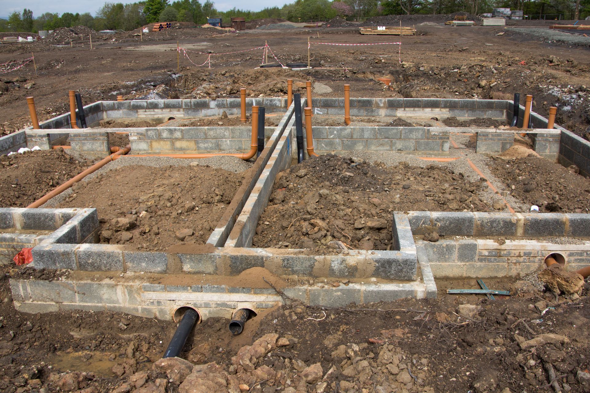 A foundation for a house is being built in a dirt field.