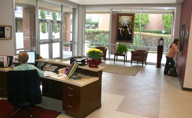 A woman is sitting at a desk in a lobby.