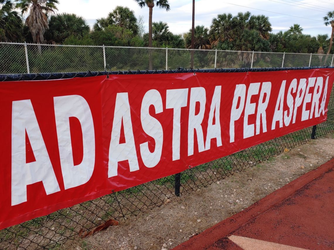 A red sign that says ad astra per asperi on it