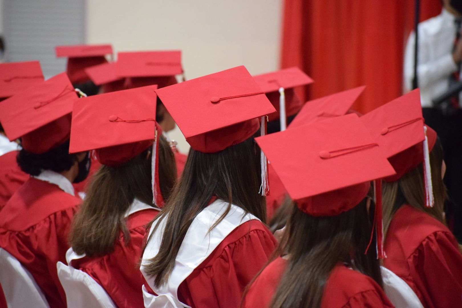 A group of graduates wearing red caps and gowns