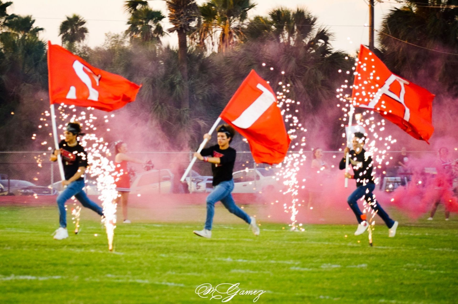 A group of people holding red flags with the letter a on them