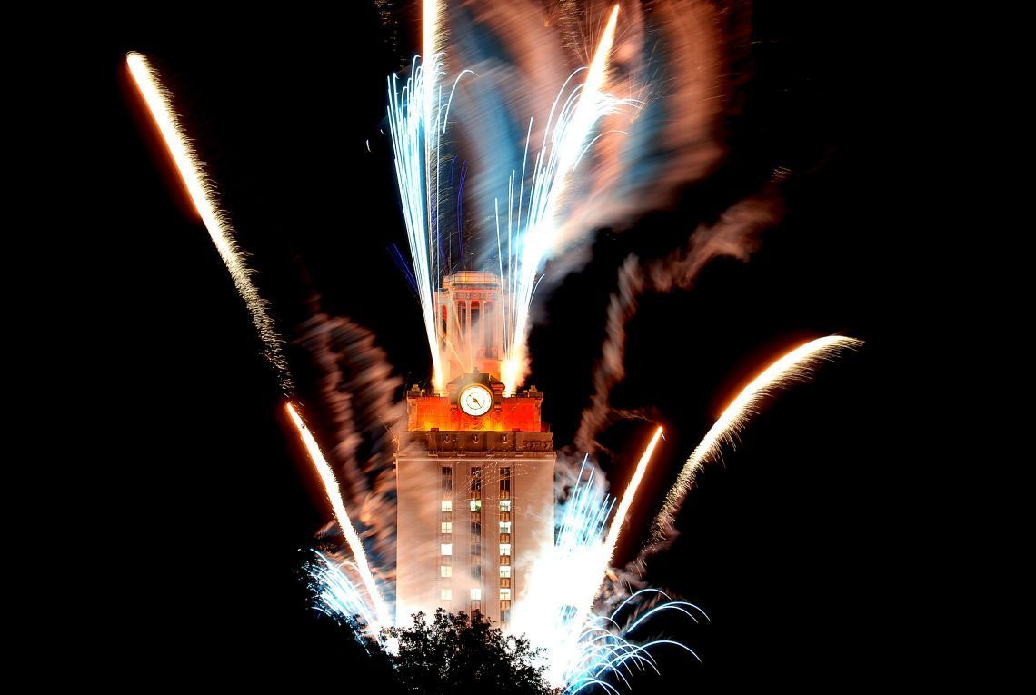 Fireworks are displayed in front of a clock tower