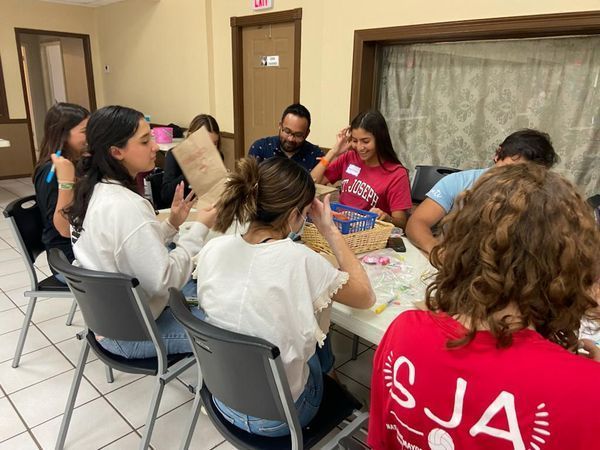 A group of people are sitting around a table in a room.