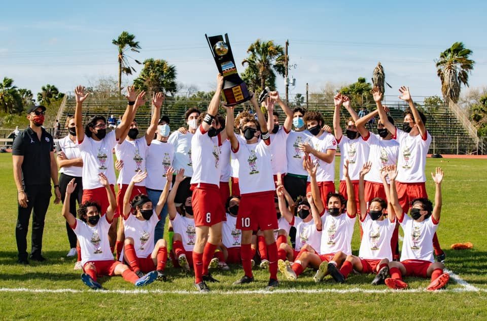 A group of soccer players are posing for a picture on a field.
