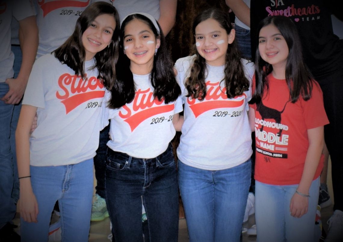 A group of girls wearing shirts that say sticks