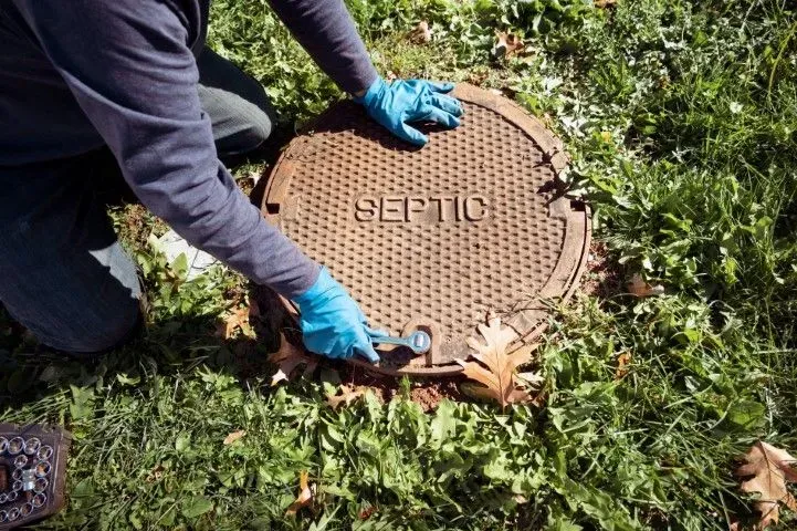 Technician repairing a heavy-duty septic tank cover.