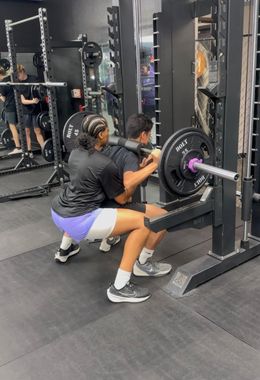 Person doing a squat on a Smith machine 