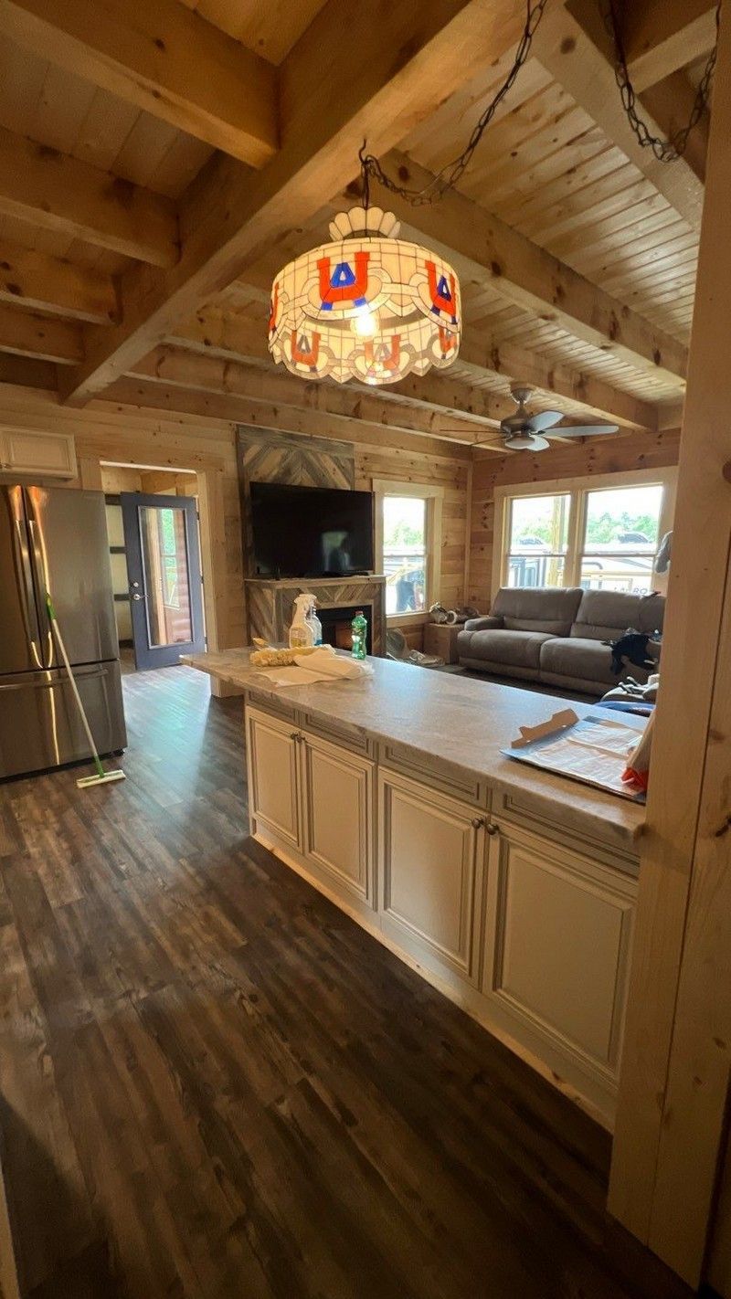 A kitchen in a log cabin with a large island in the middle of the room.