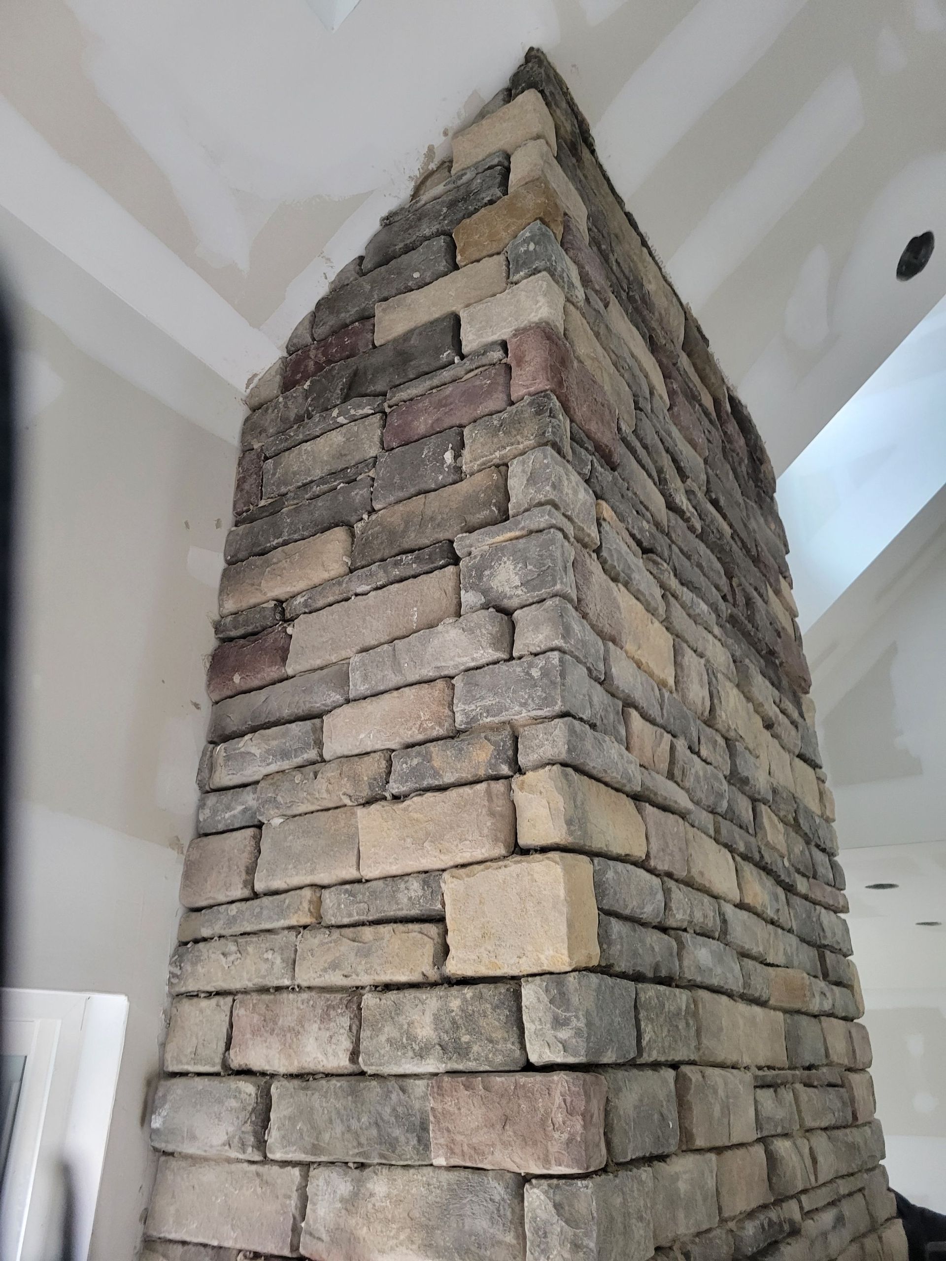 A large brick chimney is sitting in a room.