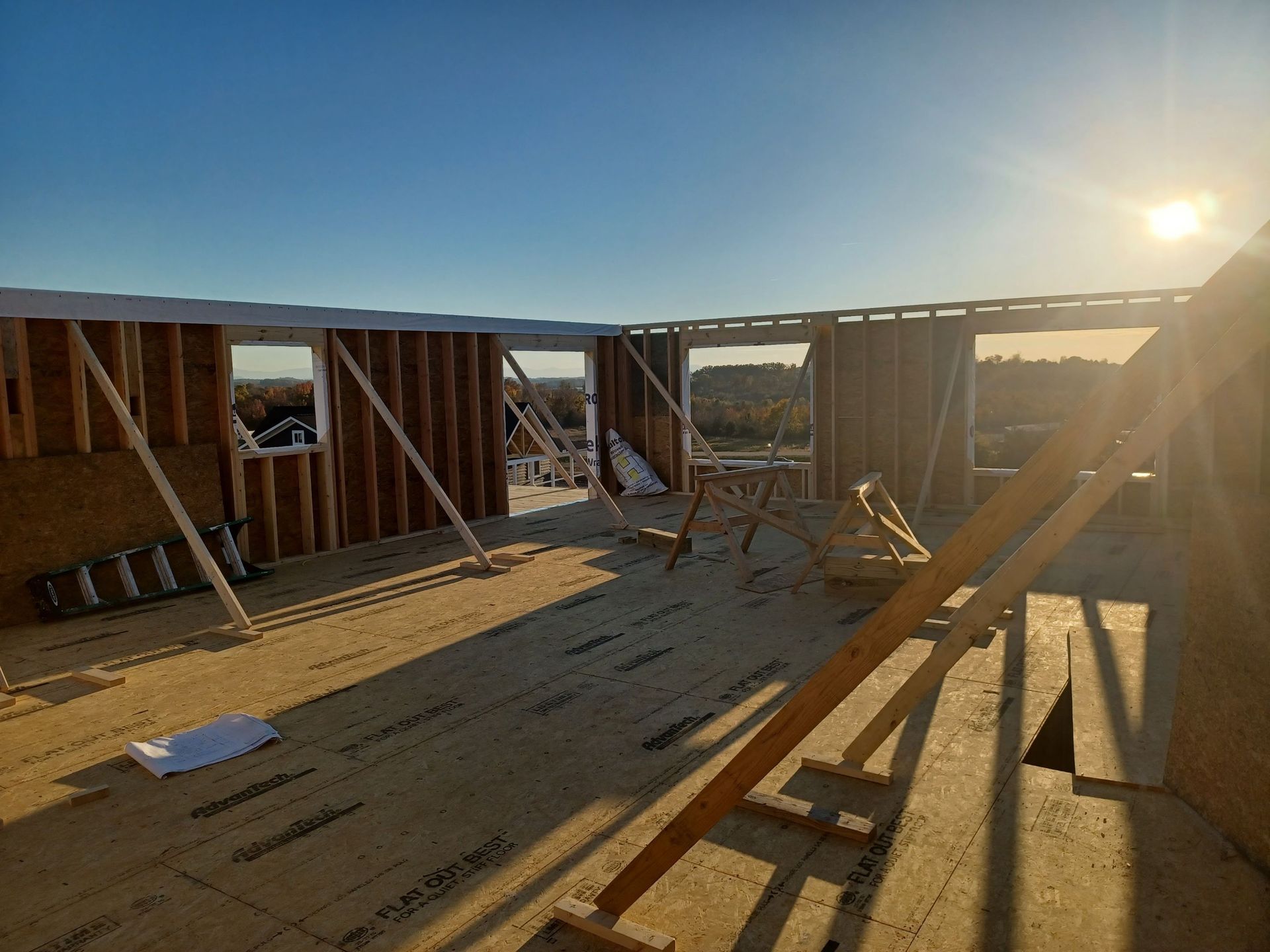 The sun is shining through the windows of a building under construction.