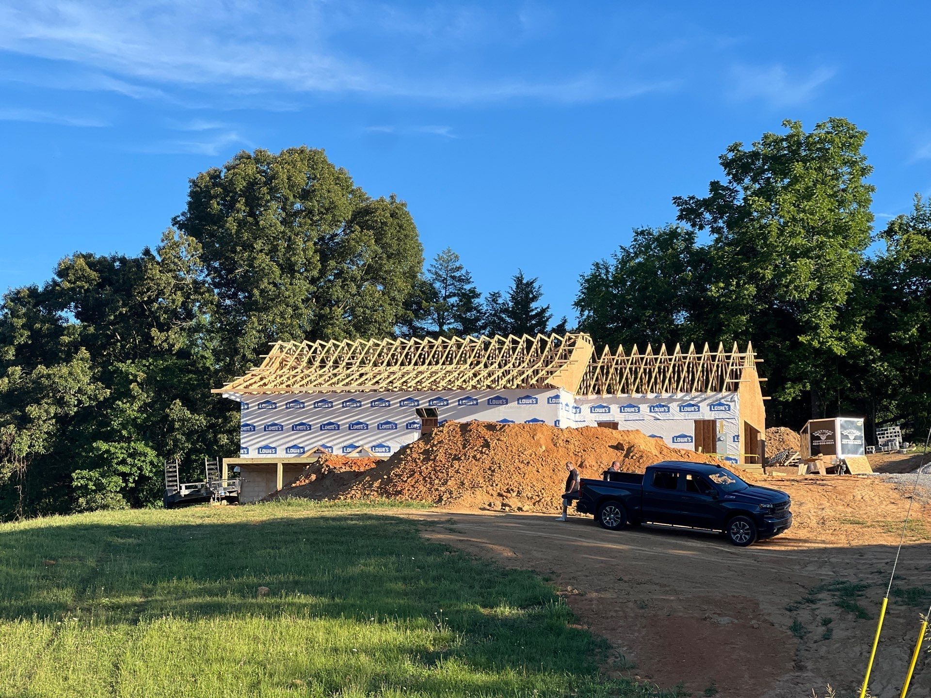 A truck is parked in front of a house under construction