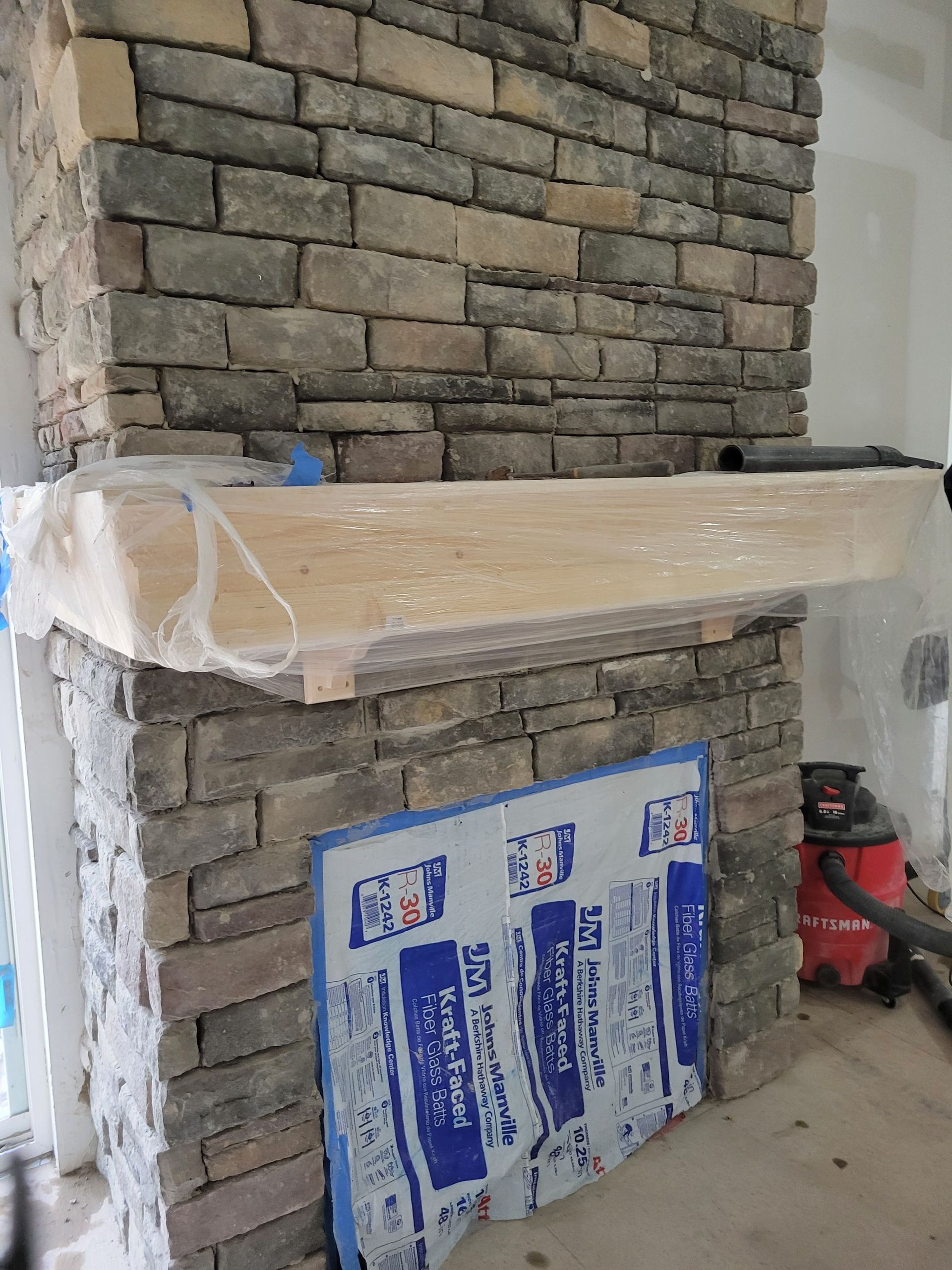 A brick fireplace with a mantle made of wood
