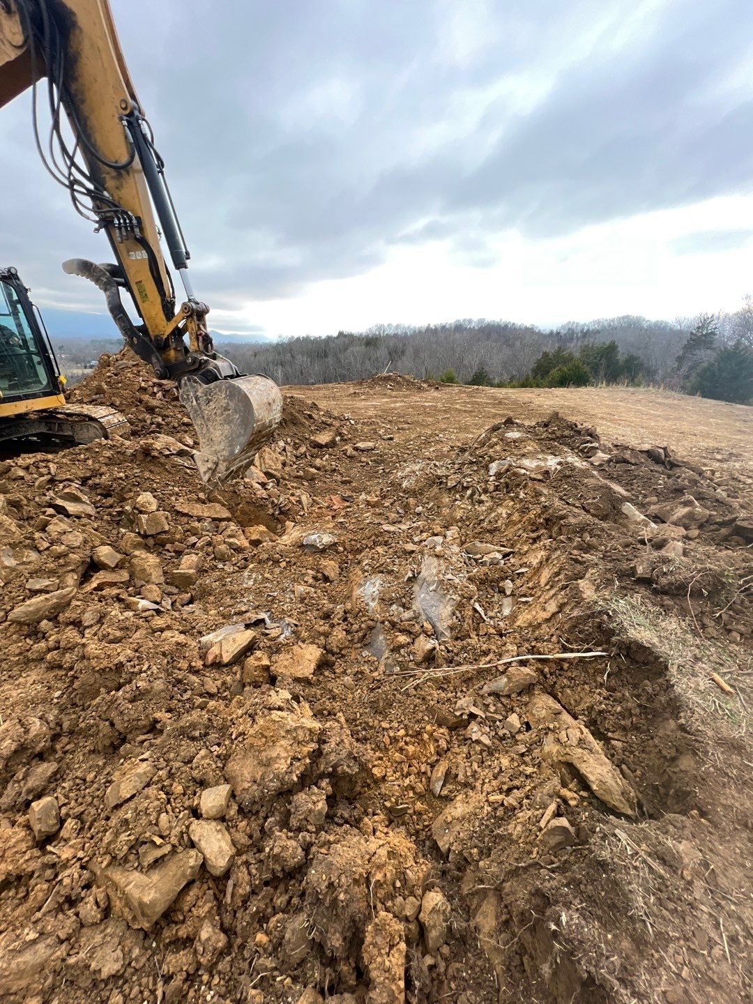 A bulldozer is digging a hole in the dirt on a construction site.