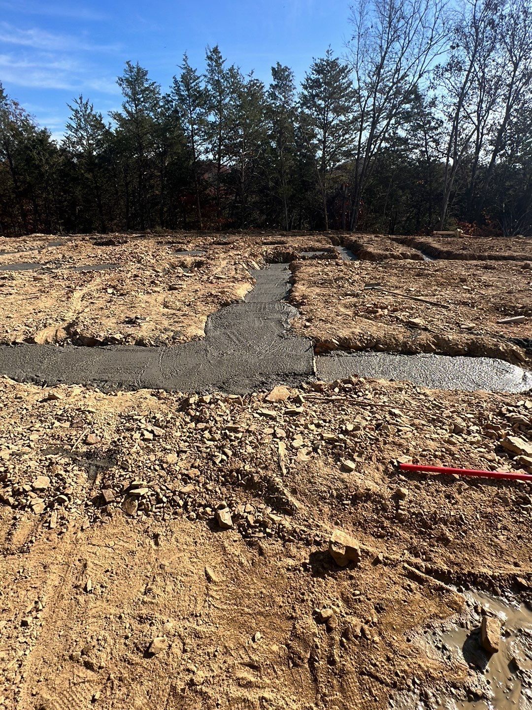 A dirt field with trees in the background and a red level in the foreground.