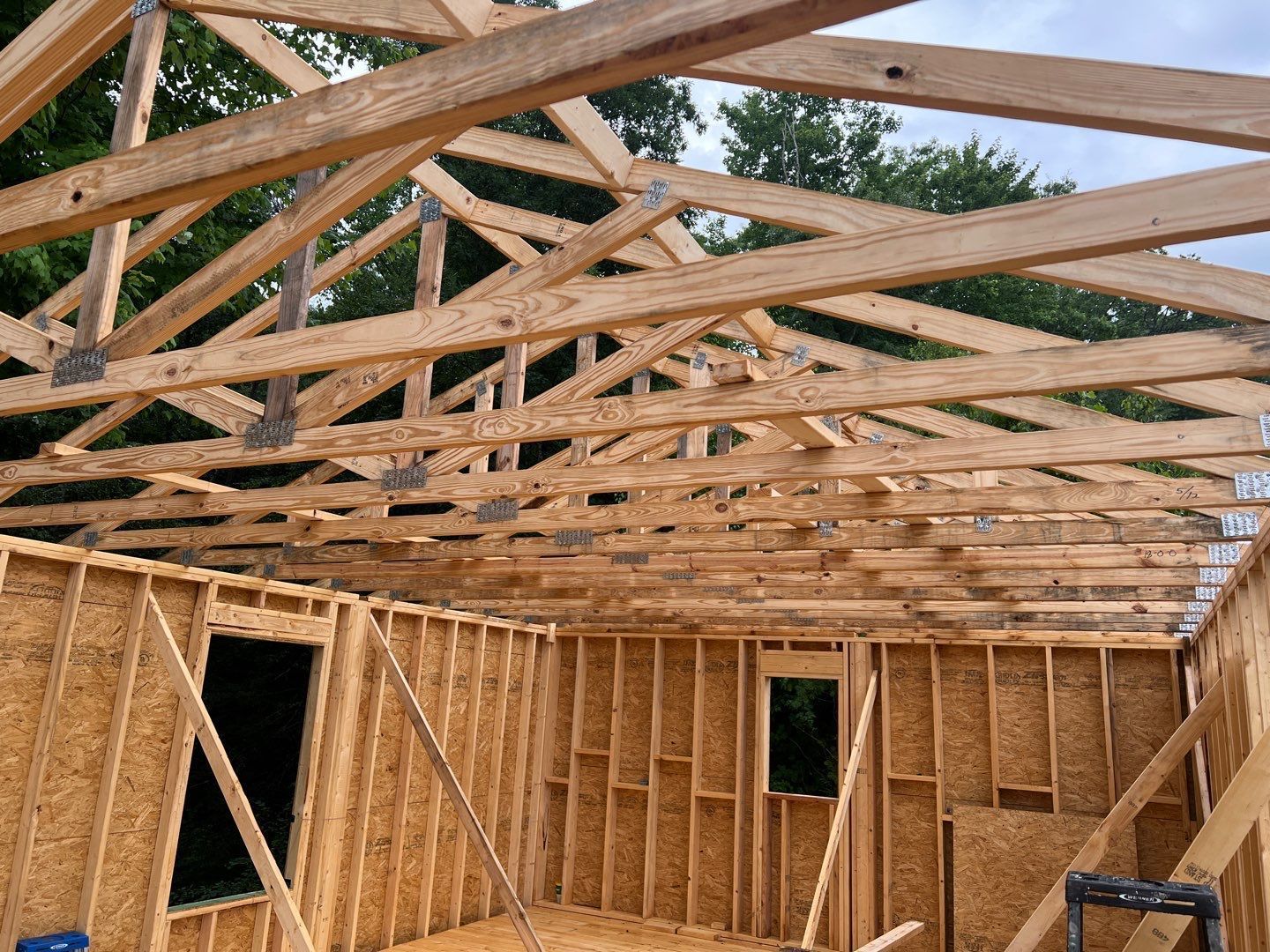 The roof of a house is being built with wooden beams.