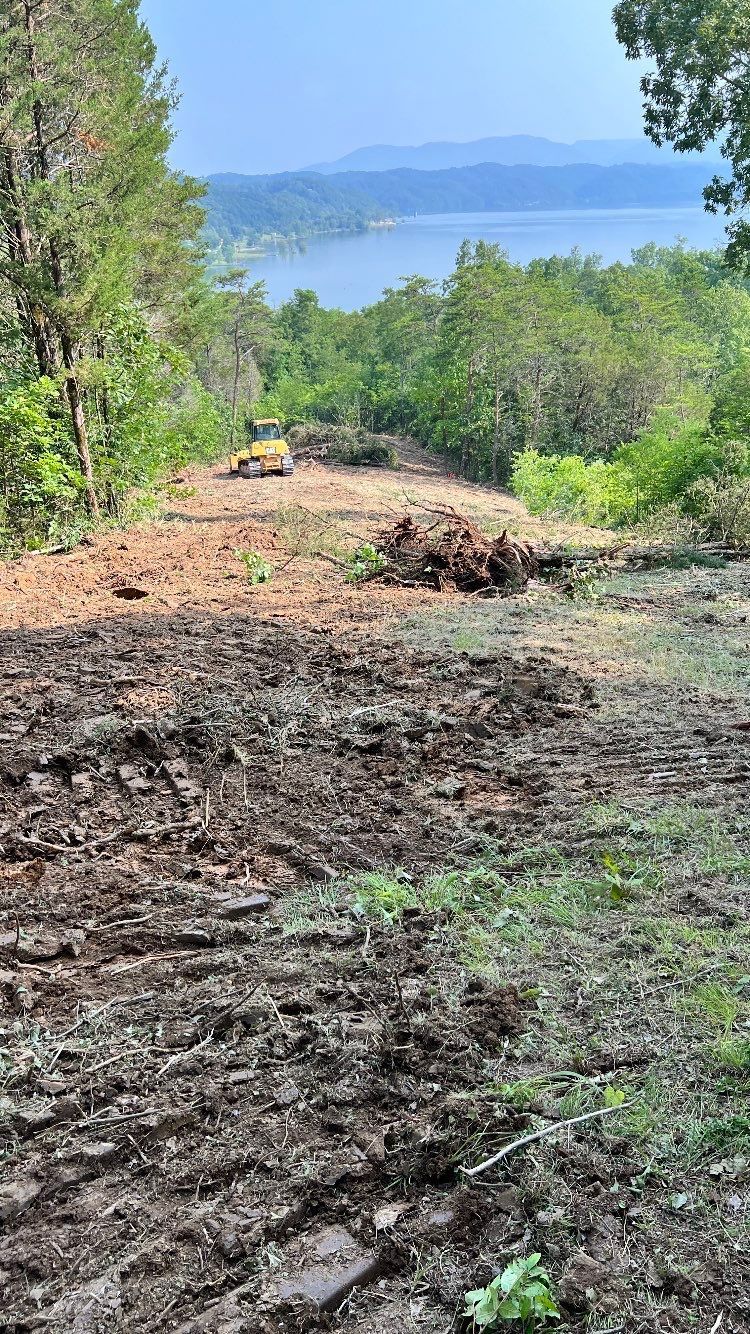 A large pile of dirt is sitting on top of a hill next to a body of water.