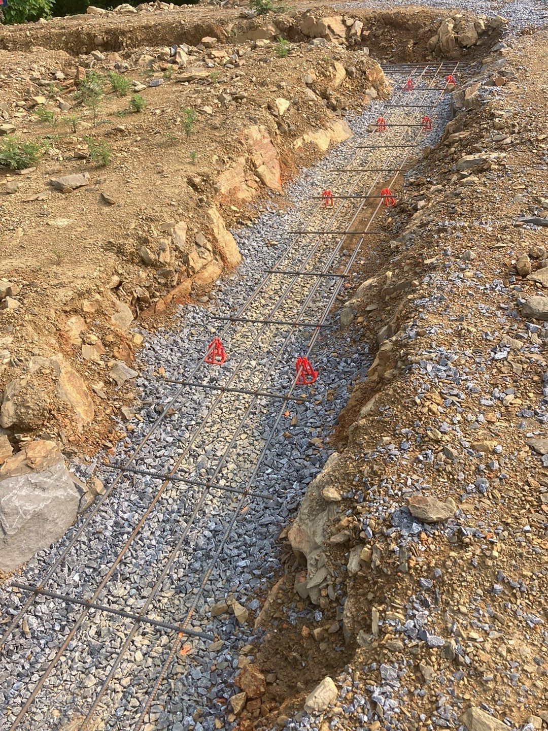 A trench in the ground with red markers on it.