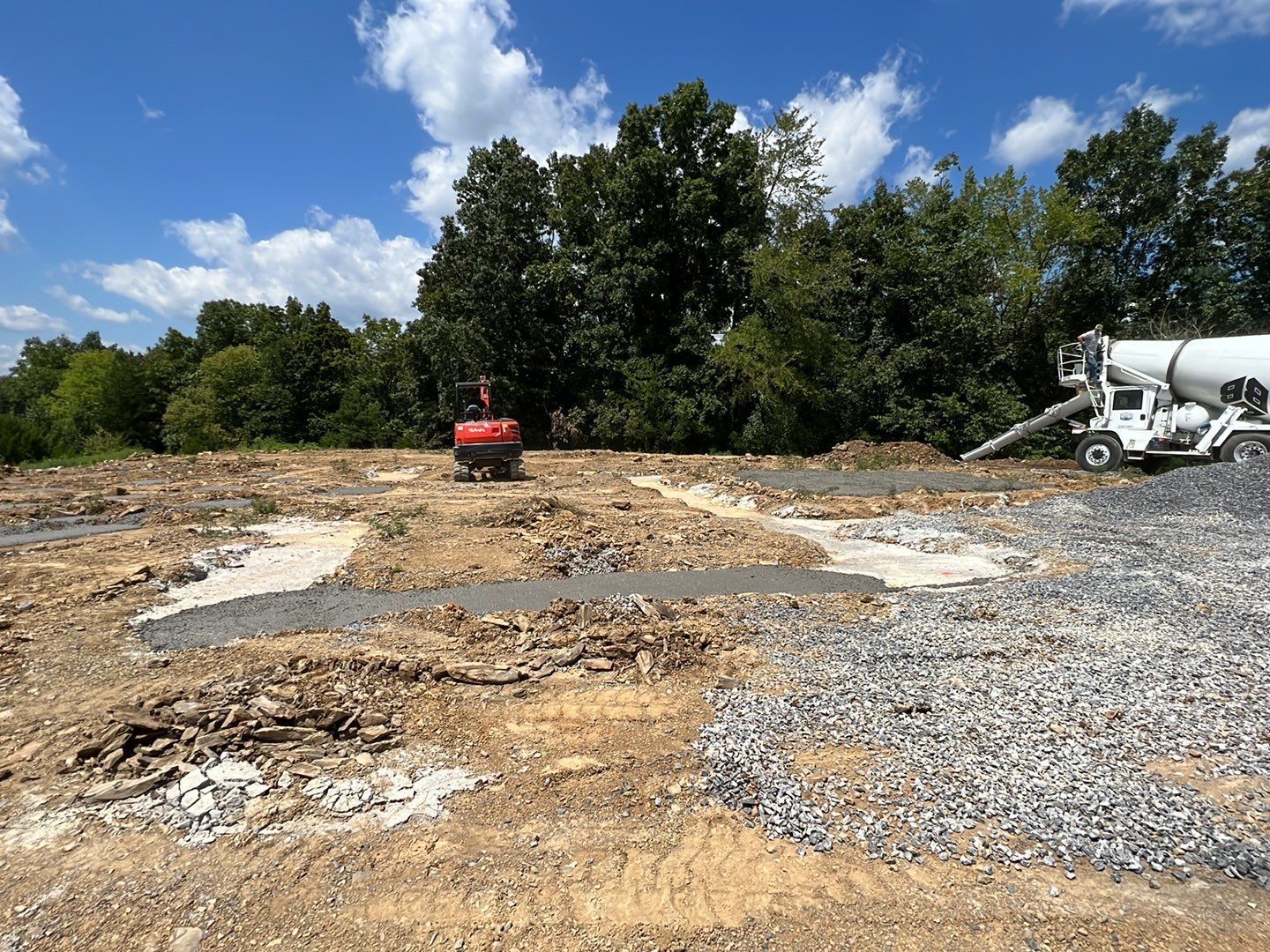 A construction site with a concrete mixer in the background.