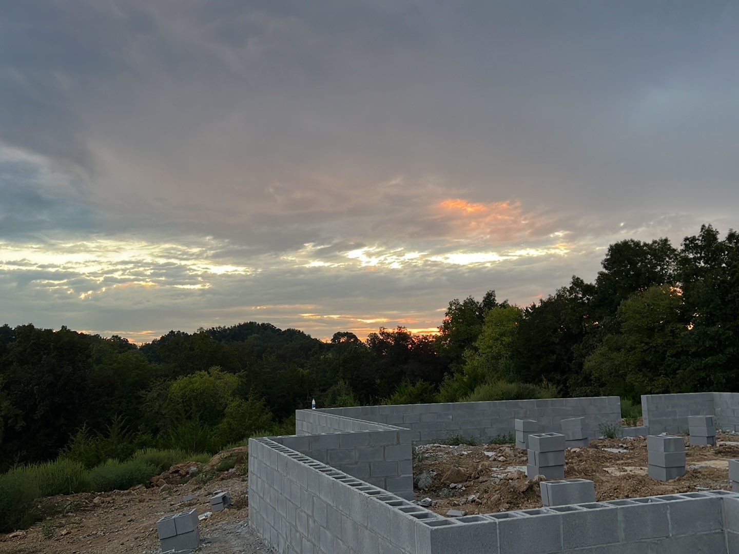 A building under construction with a sunset in the background