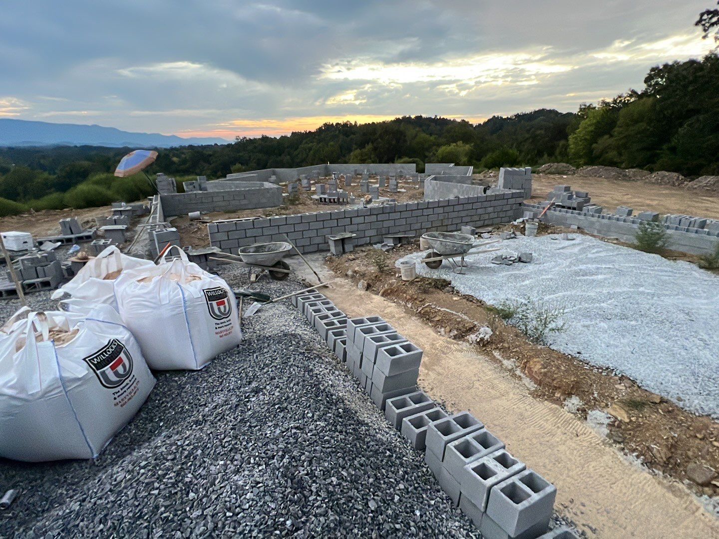 A construction site with bags of gravel and bricks.