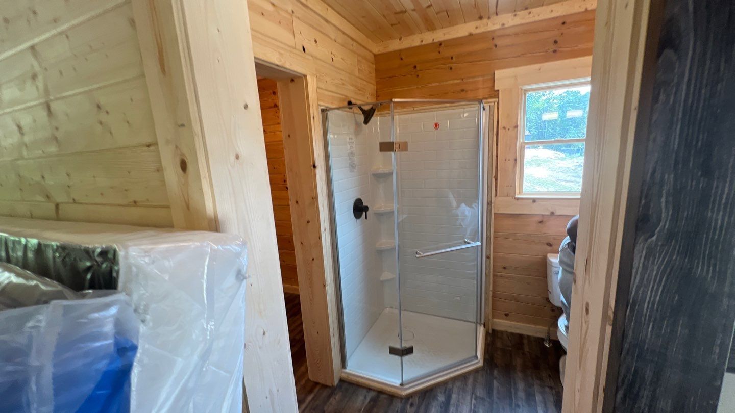 A bathroom with a walk in shower and a window.