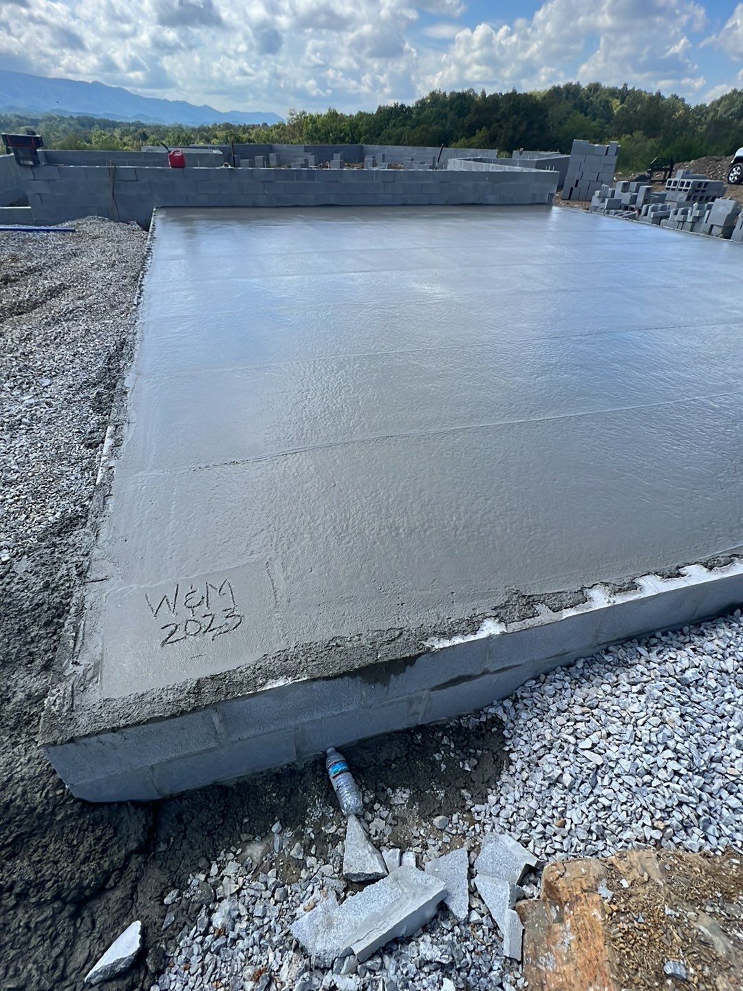 A large piece of concrete is sitting on top of a pile of gravel.