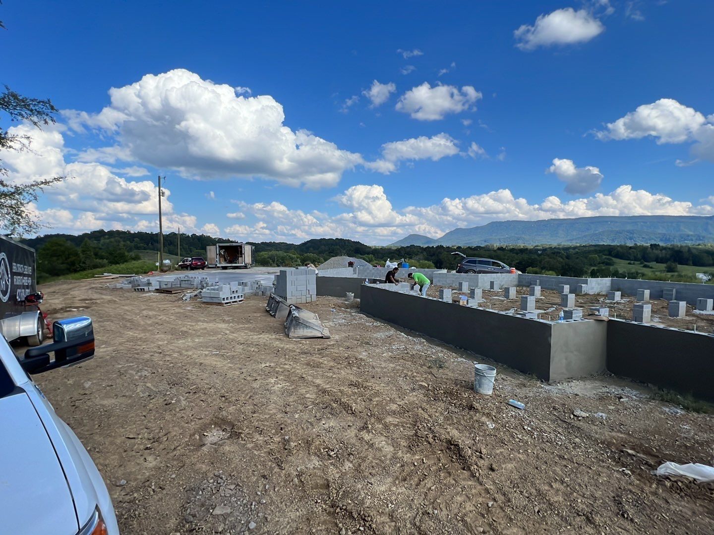 A white truck is parked in front of a construction site.