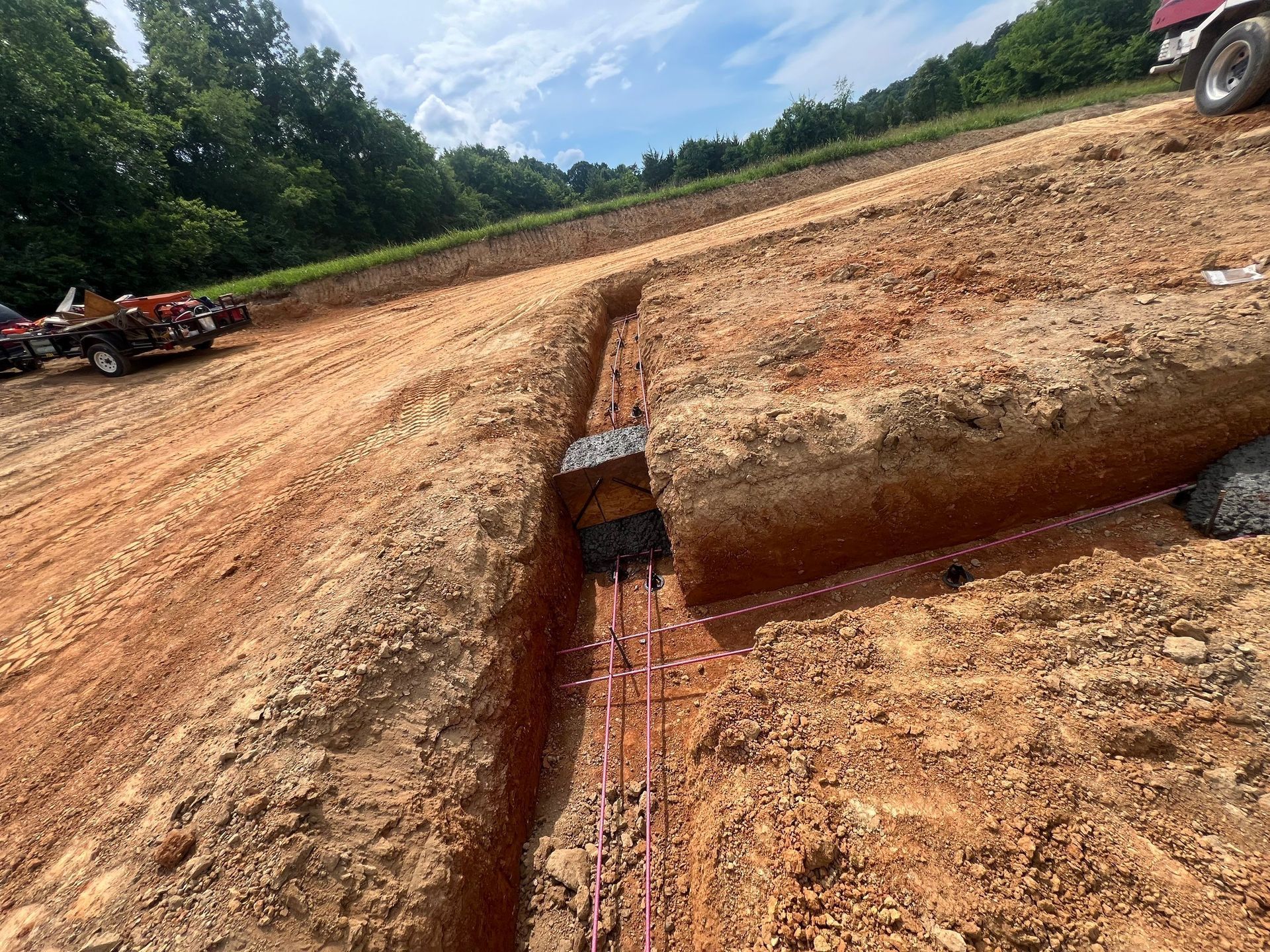 A dirt road with a truck parked on the side of it.