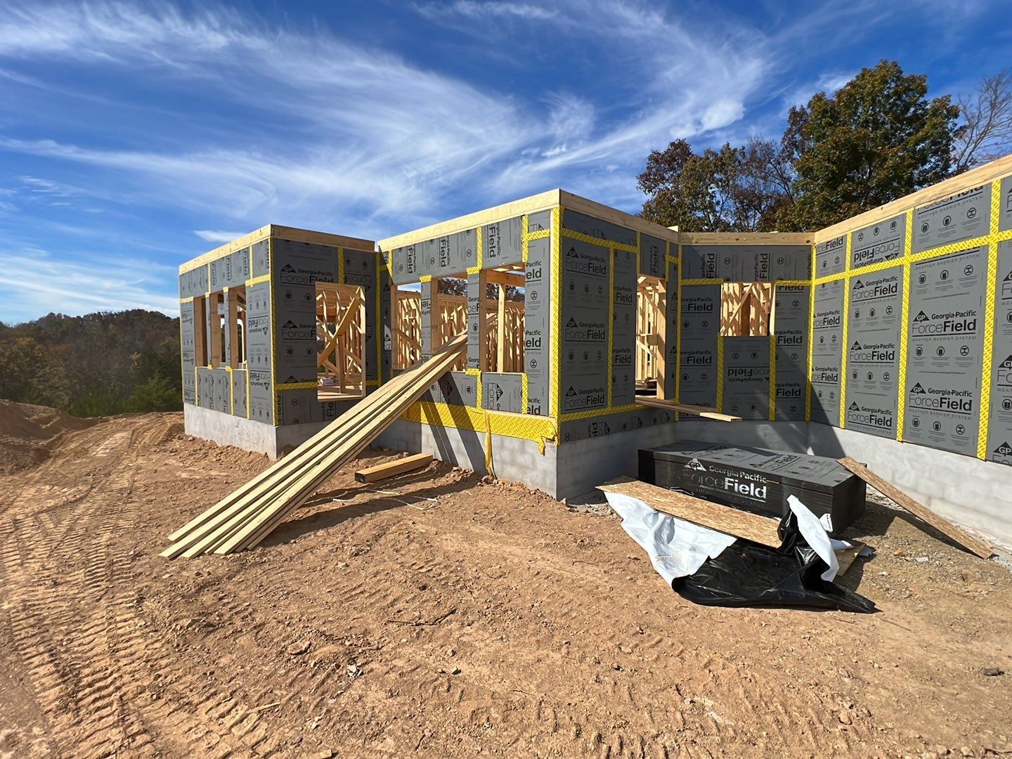 A house is being built in the middle of a dirt field.