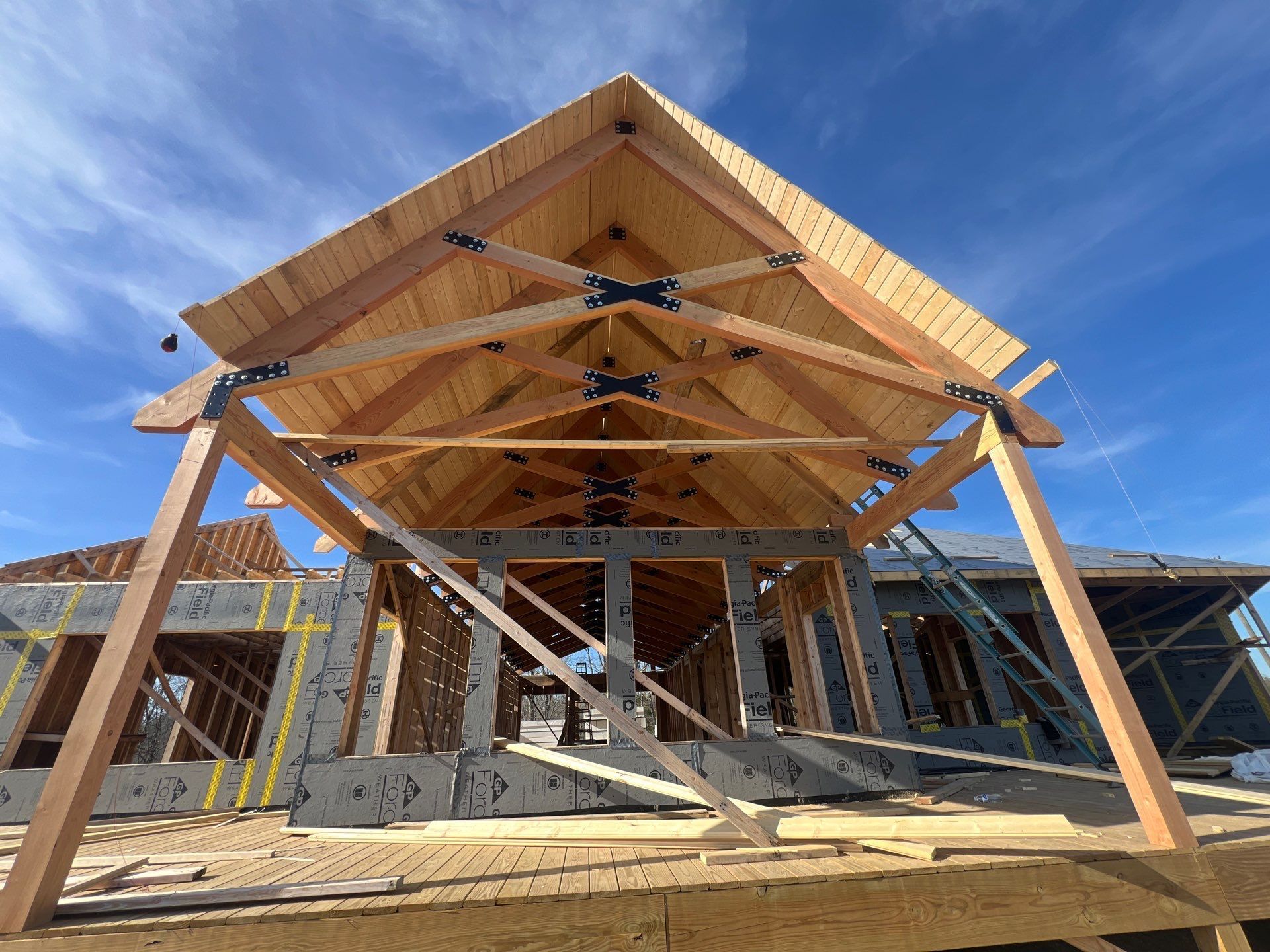 A house is being built with wooden beams and a roof.