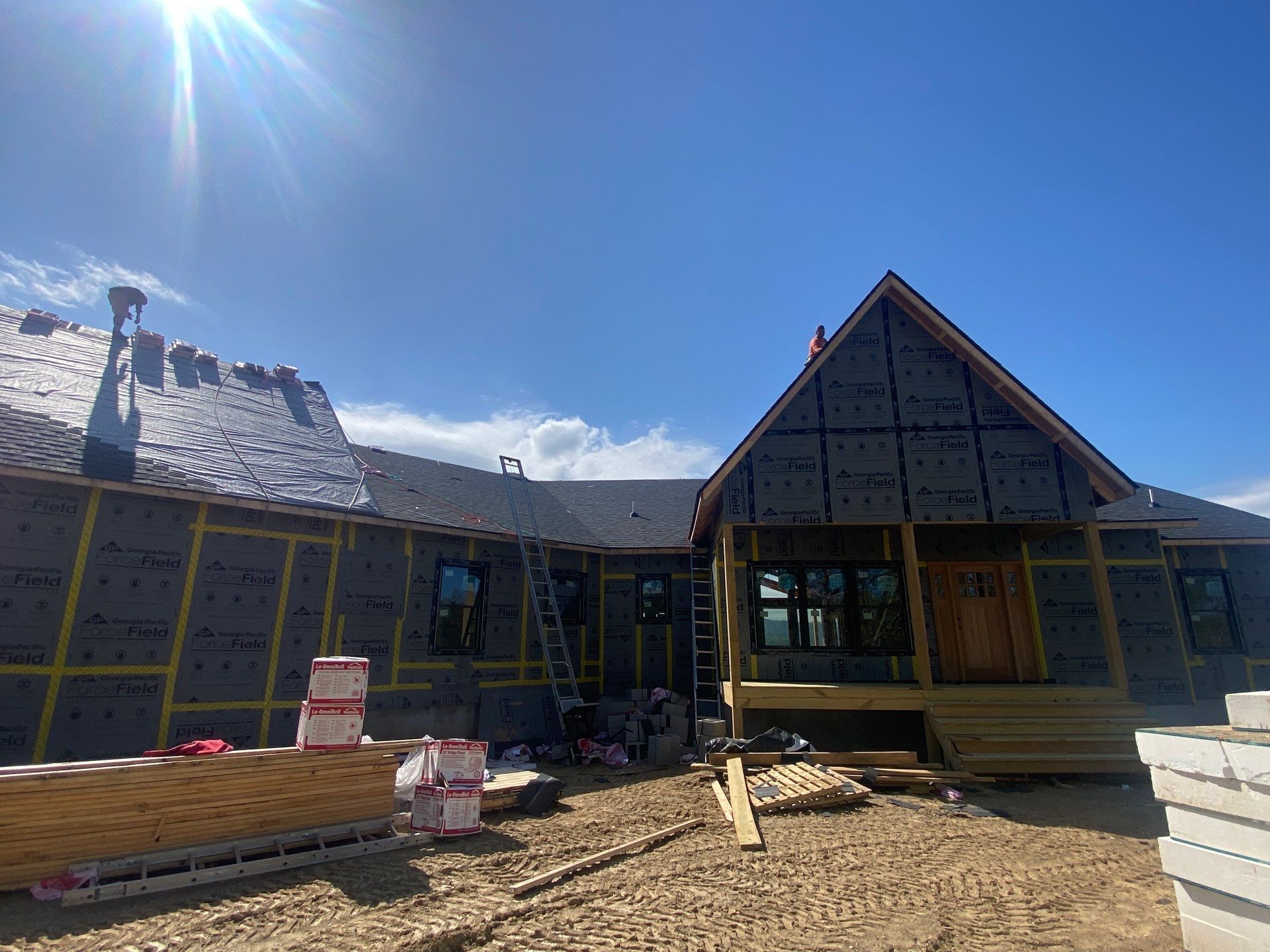 A house is being built in the middle of a dirt field.