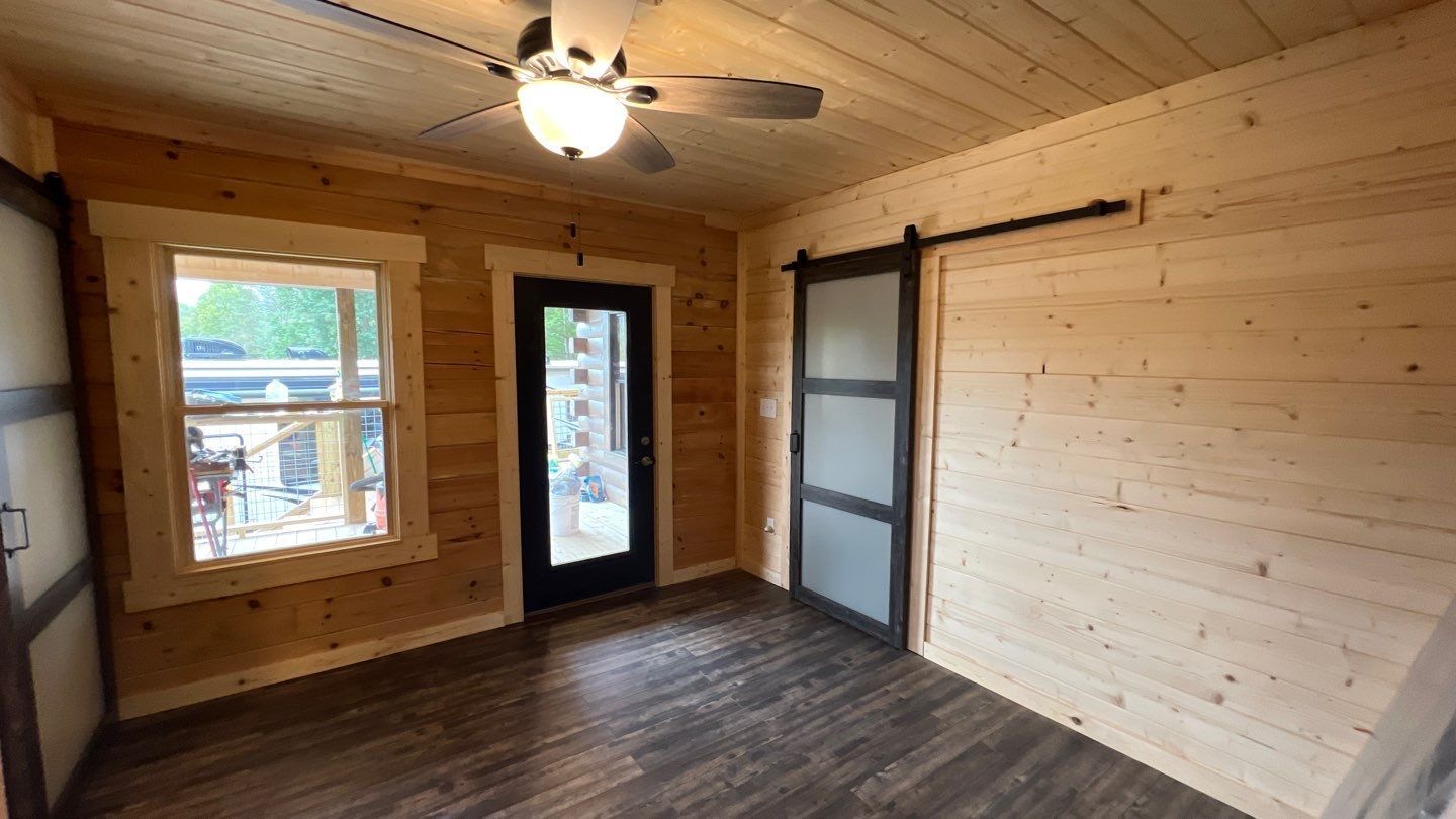 There is a ceiling fan in the room and a sliding barn door.