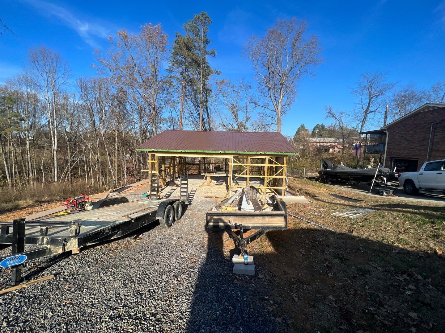 A trailer is parked in front of a house under construction.