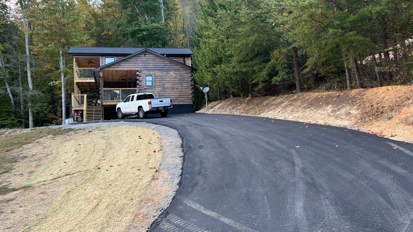 A truck is parked in front of a house on a curvy road.