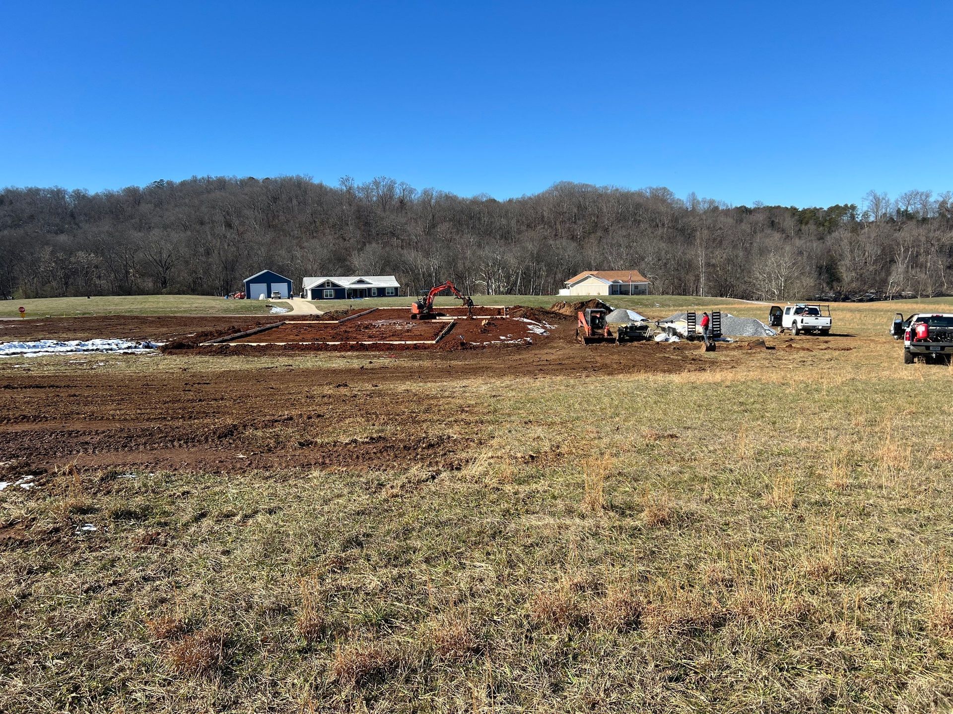 A large field with a lot of dirt and trucks in it.