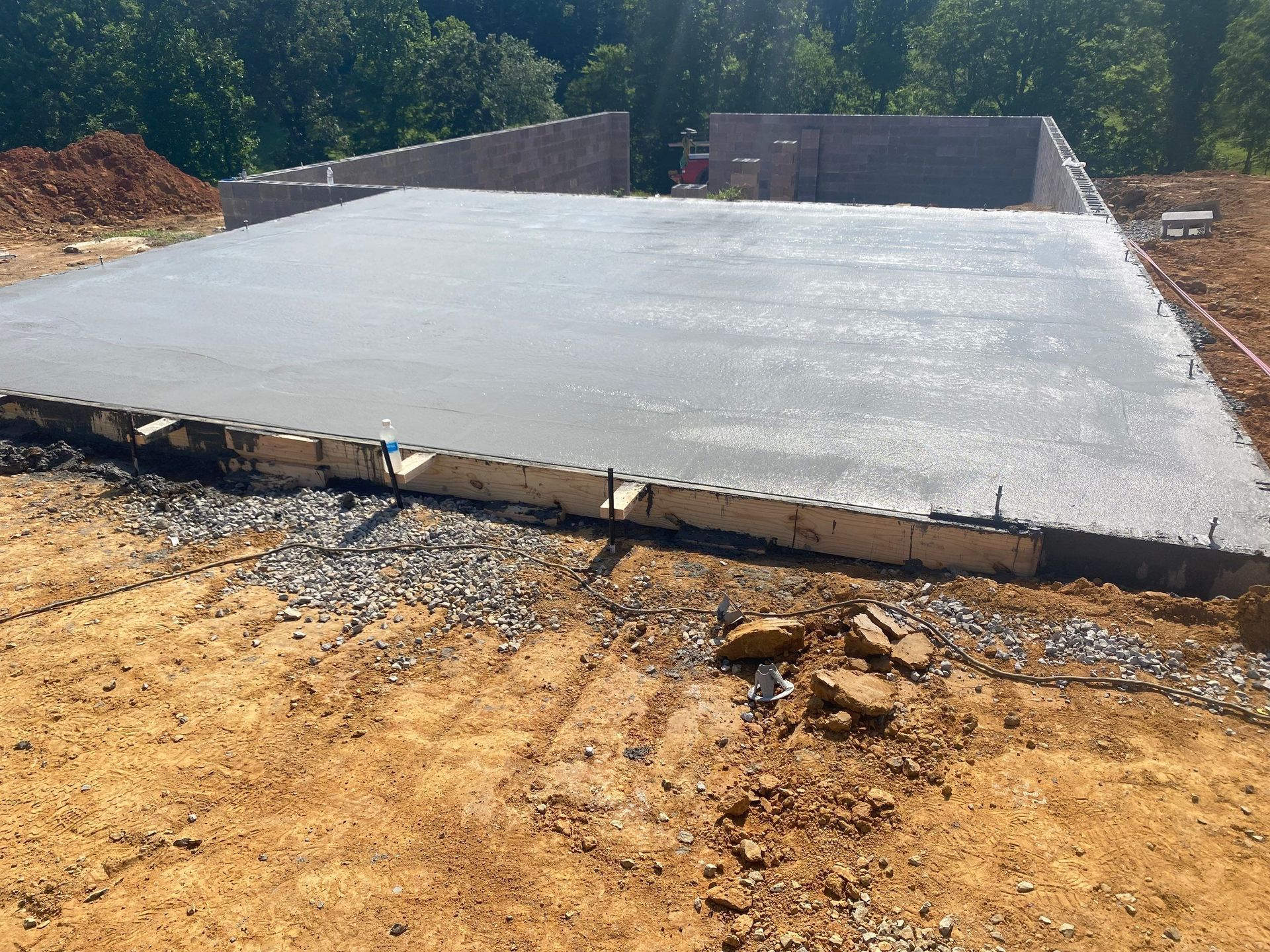 A large concrete slab is sitting on top of a dirt field.