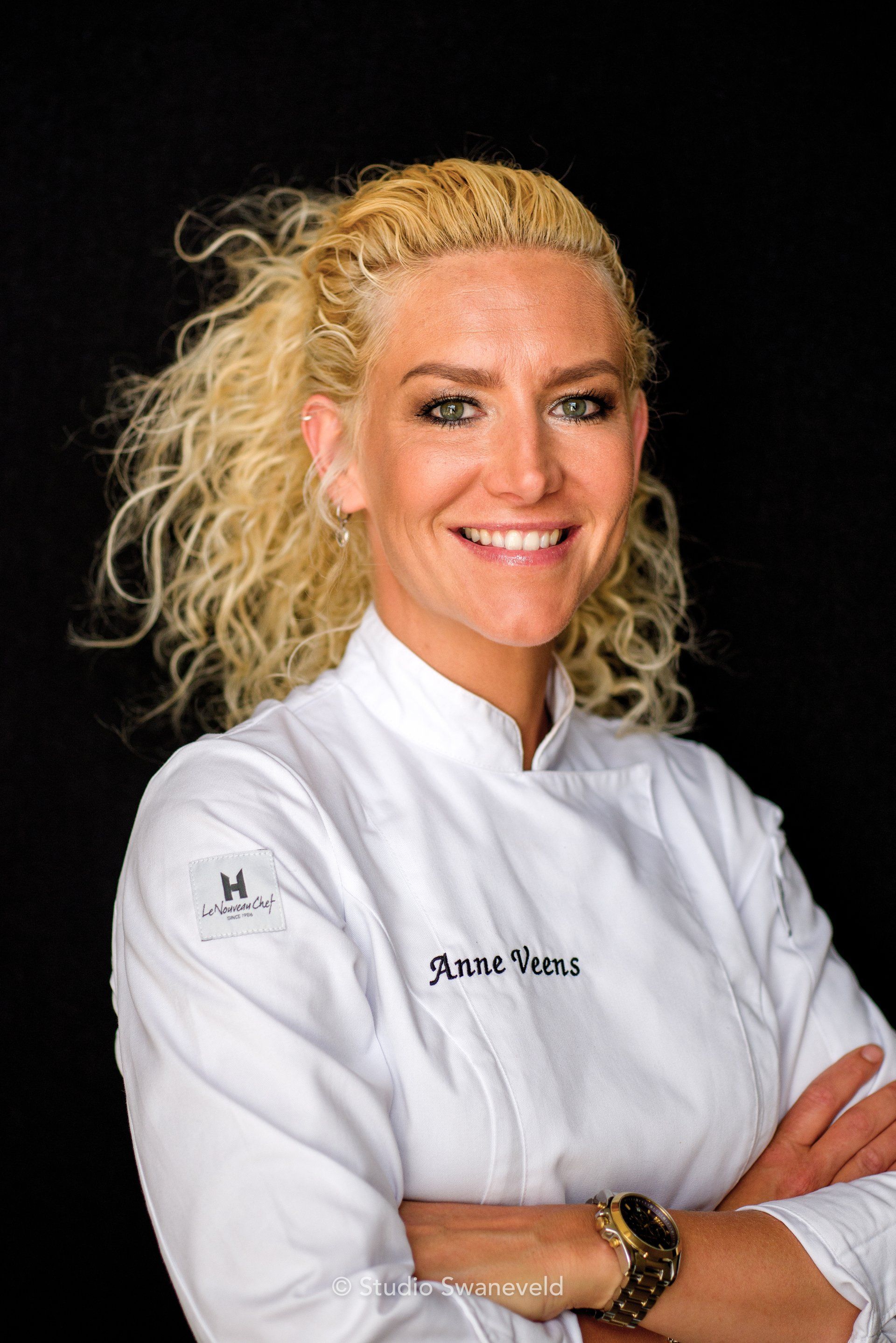 portret van Anne, gekleed in koksuniform tegen zwarte achtergrond