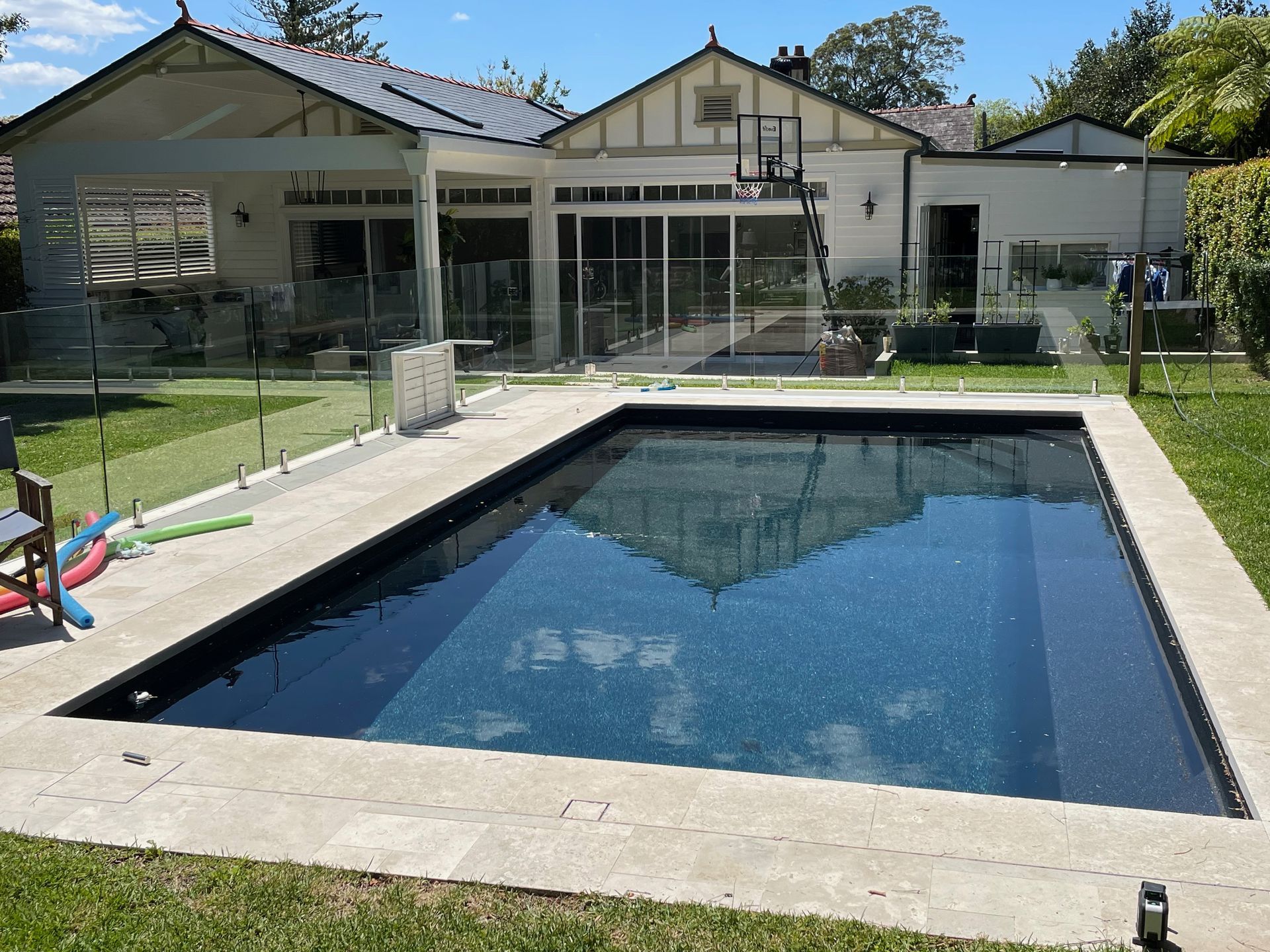 A large swimming pool in front of a house