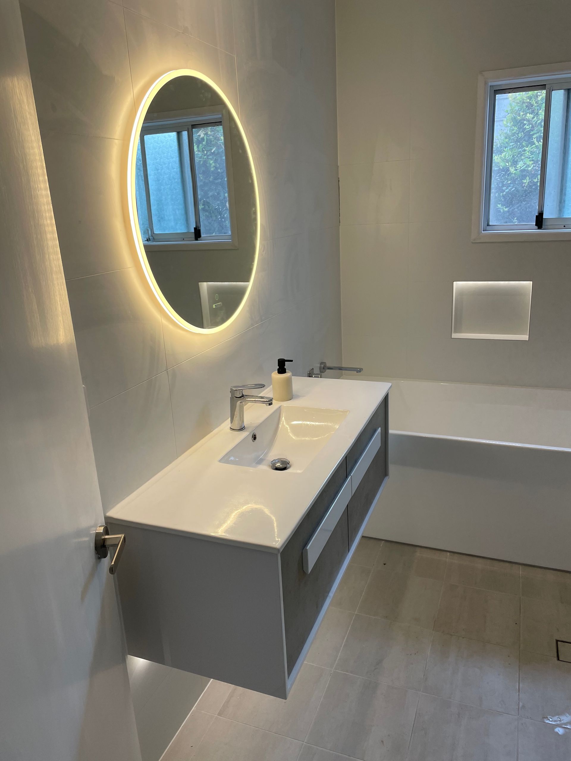 A bathroom with a sink , mirror and bathtub.