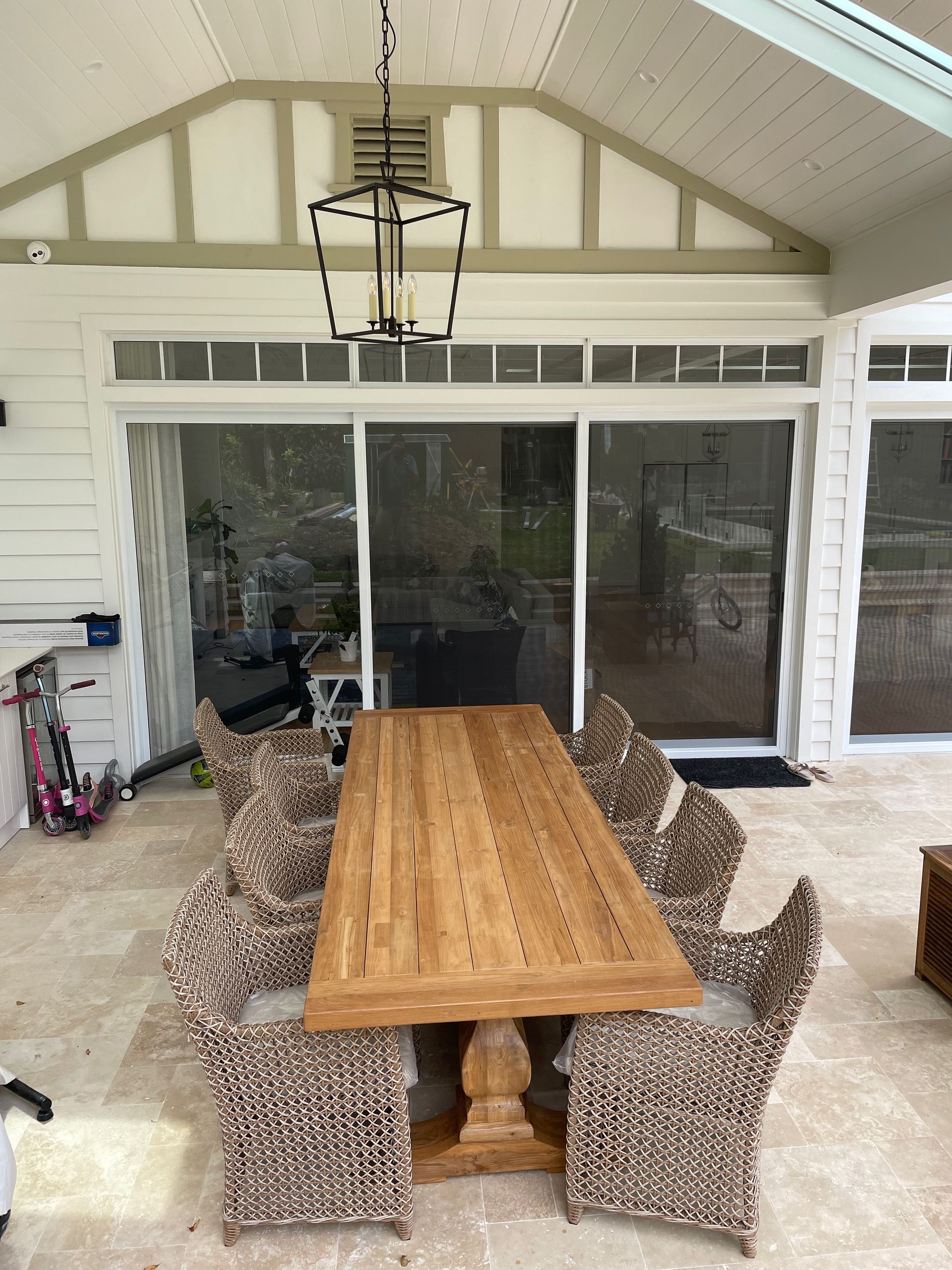 A wooden table and chairs are sitting on a patio.