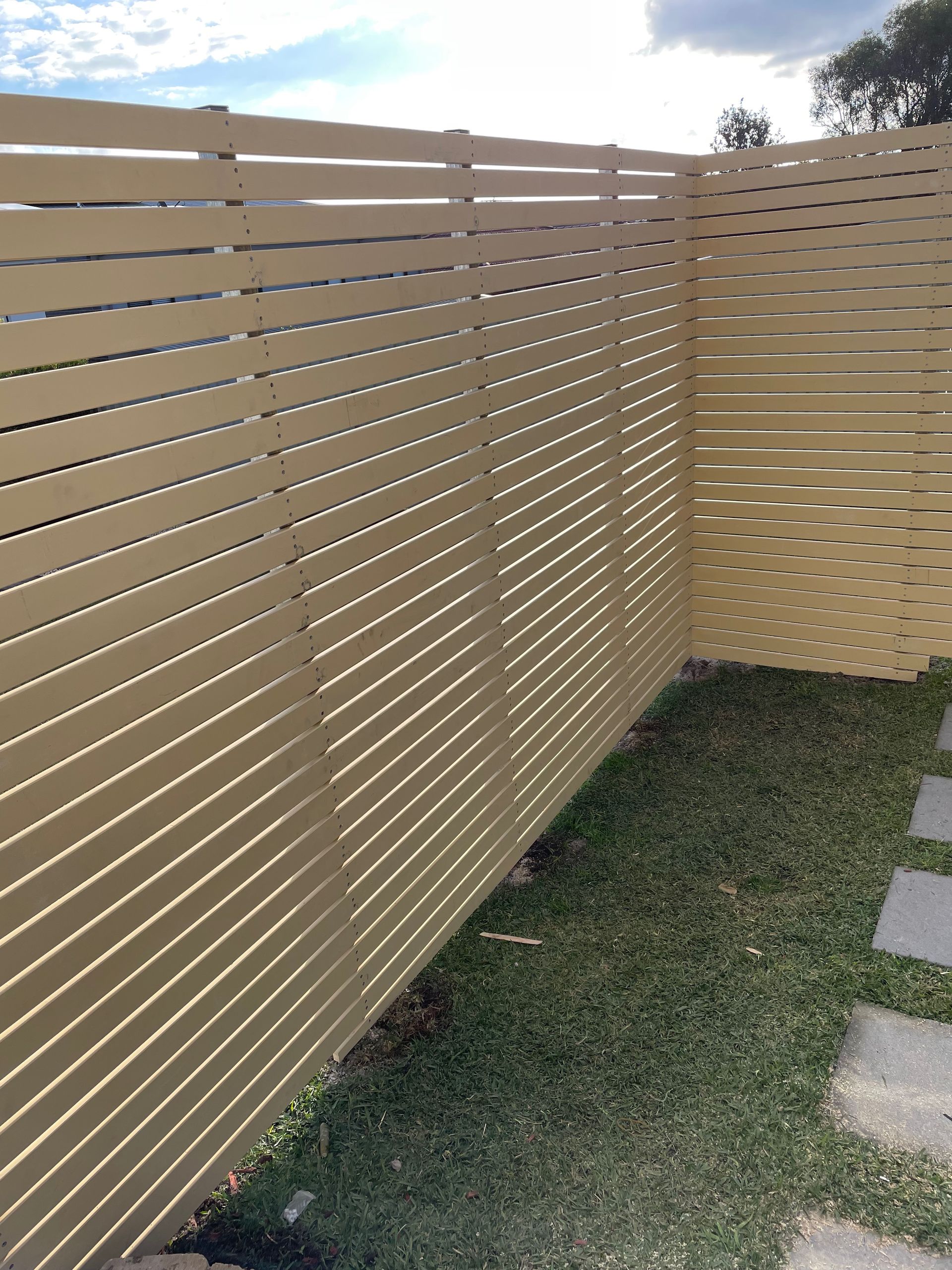 A wooden fence is sitting on top of a lush green lawn.