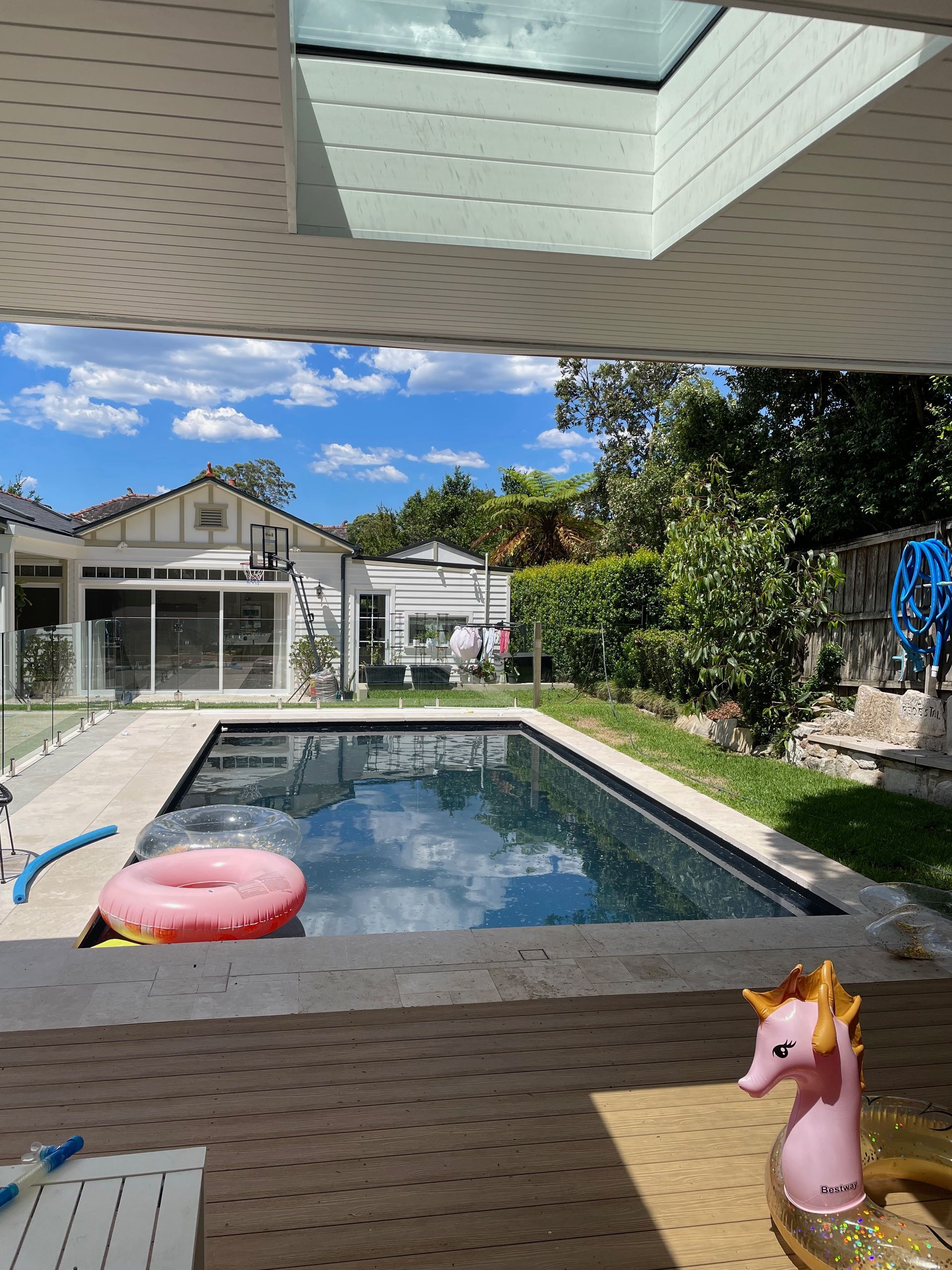 A large swimming pool with a pink unicorn float in the water.