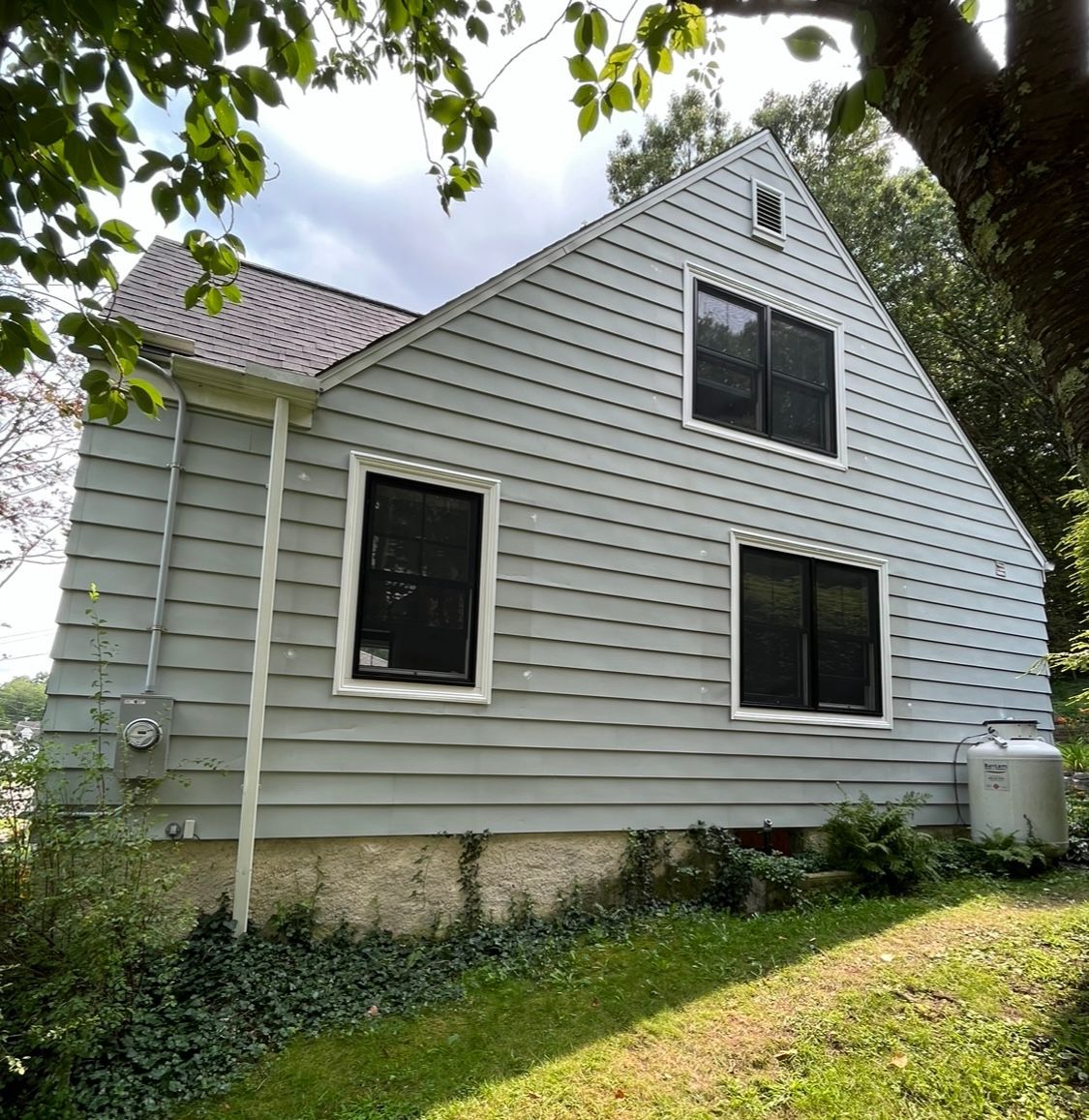 A white house with a triangle roof and a lot of windows