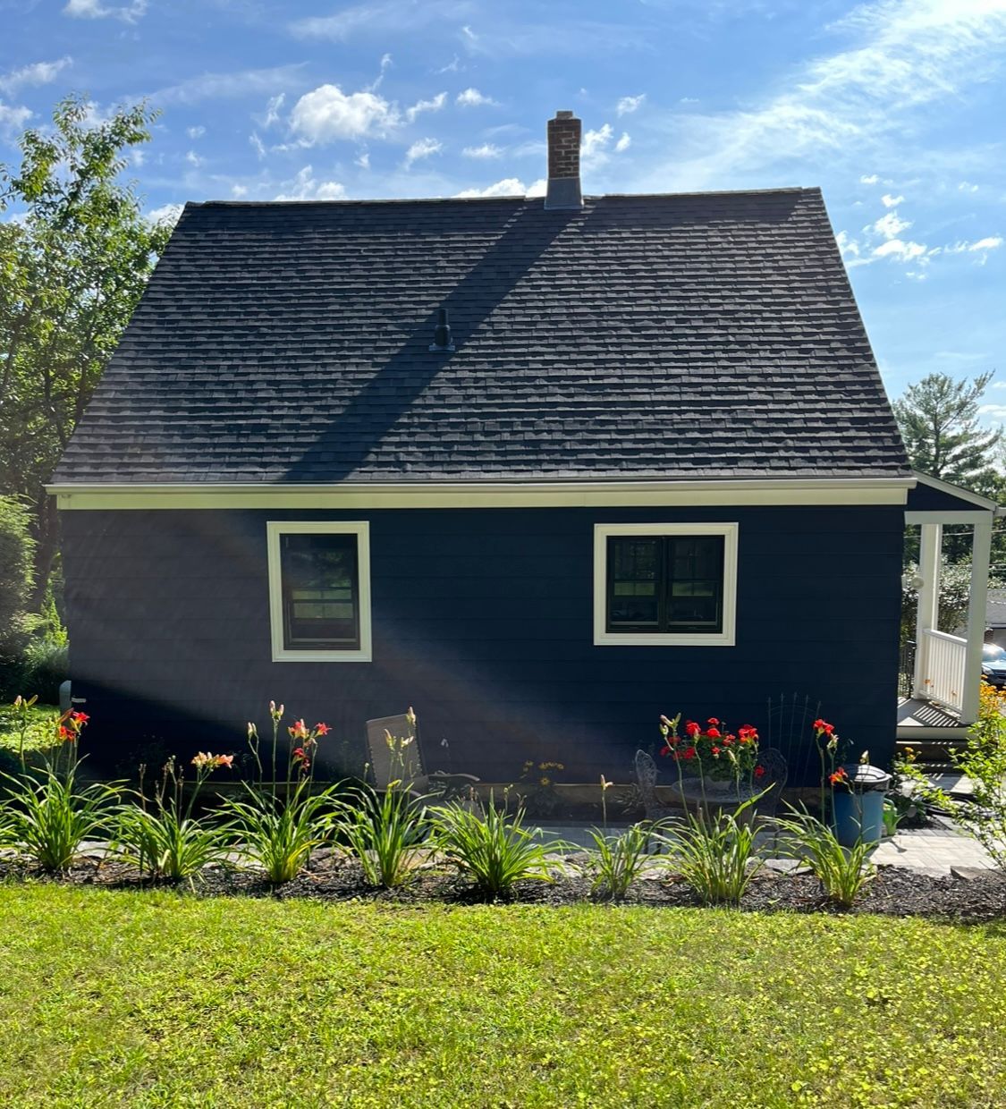 A small black house with a slate roof