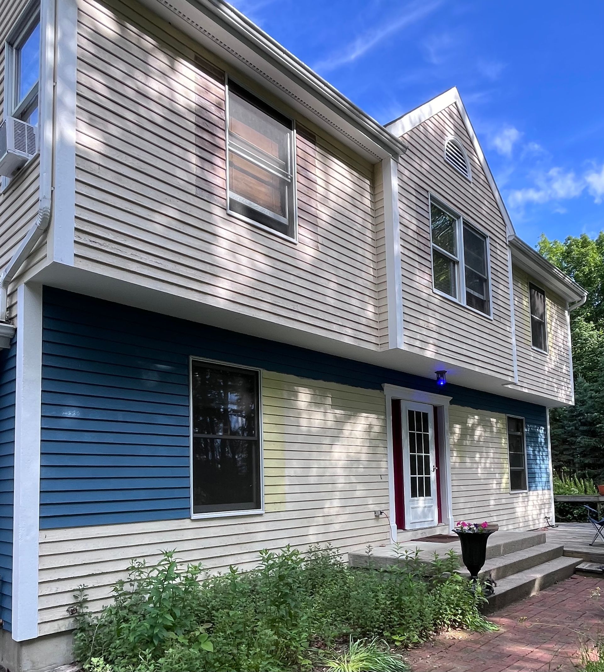 A large house with blue and white siding and a lot of windows